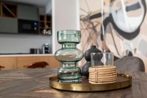 szklaną wazę na złotej płytce z kubkiem na stole w obiekcie Duett - Urban Rooms w Győr