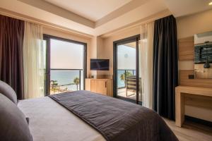 a bedroom with a bed with a view of the ocean at MAIA Luxury Beach Hotel & Spa in Guzelcamlı