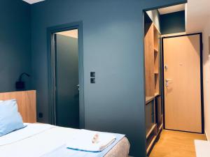 a bedroom with blue walls and a bed with a mirror at Metropolitan Complex budget room@Faliro in Piraeus