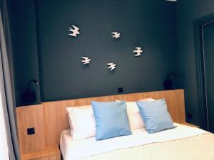 um quarto com uma cama com borboletas brancas na parede em Metropolitan Complex budget room@Faliro em Piraeus