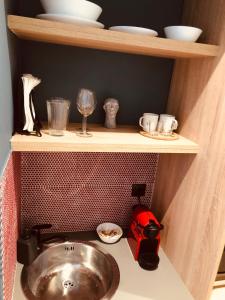 - une cuisine avec un évier et une étagère avec de la vaisselle dans l'établissement Metropolitan Complex budget room@Faliro, au Pirée