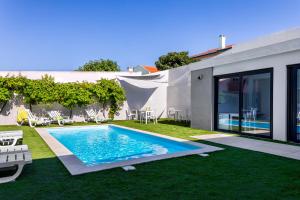 a swimming pool in the backyard of a house at Ilheu 25 Peniche House in Peniche