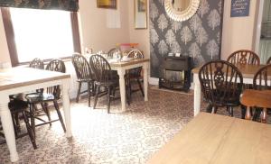 a dining room with a table and chairs and a wood stove at Tynedale Guest House in Penrith