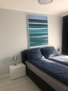 um quarto com uma cama e uma janela com o oceano em Apartamenty Morskie Gardenia 2 em Dziwnów