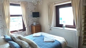 a bedroom with a bed with two towels on it at Tynedale Guest House in Penrith