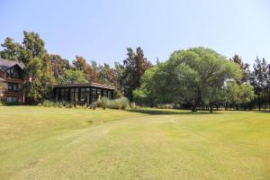 een golfbaan met een huis en een groene tuin bij La Posta del Pilar Hotel & Spa in Pilar