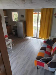 a living room with a couch and a desk at CÉVENNES MAISONNETTE DANS RÉSIDENCE DE VACANCES in Sauve +6 photos