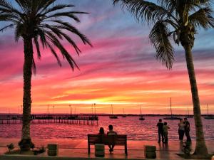 a group of people sitting on a bench watching the sunset at Seven Crown La Paz Centro Historico in La Paz
