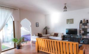 sala de estar con sofá y TV en Casa La Kasbah, en Cruz de Huanacaxtle