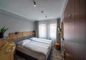ein Hotelzimmer mit einem Bett und einem Fenster in der Unterkunft Duett - Urban Rooms in Győr