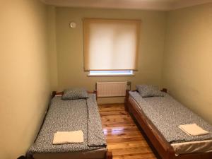dwa łóżka w pokoju z oknem w obiekcie SIA Cikstonis w Rydze