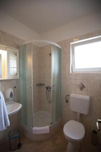 a bathroom with a shower and a toilet and a sink at Villa Tamaris in Rab