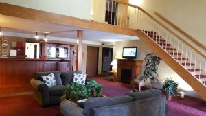sala de estar con sofá y escalera en Guest Lodge Motel en Minot