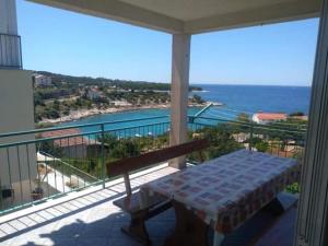 a balcony with a table and a view of the ocean at Denis Bolanča in Primošten