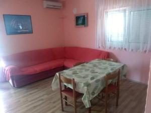 a living room with a red couch and a table at Denis Bolanča in Primošten