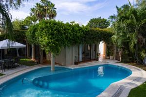 a swimming pool with a hedge around a house at Casa La Kasbah in Cruz de Huanacaxtle