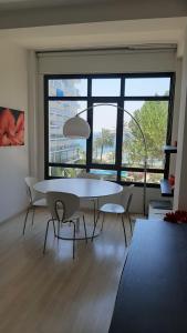 una mesa y sillas blancas en una habitación con una ventana grande en Skol 235B by Completely Marbella, en Marbella
