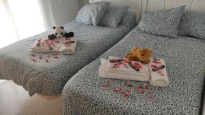 Duas camas com panda de peluche e ursinhos de peluche. em Casa el Anden 11 em El Bosque