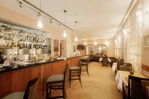 um restaurante com um bar e algumas mesas e cadeiras em Venus em Karlovy Vary
