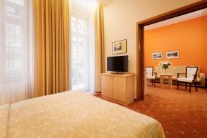 a hotel room with a bed and a television at Venus in Karlovy Vary