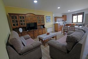 ein Wohnzimmer mit 2 Sofas und einer Küche in der Unterkunft Los fresnos de ribadesella 4 personas in Ribadesella