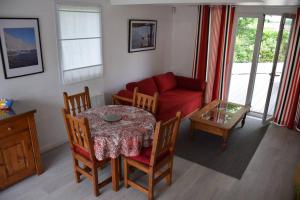 a living room with a table and a red couch at Dokaetchea in Urrugne