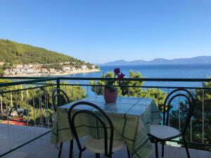 een tafel op een balkon met uitzicht op het water bij Rooms with shared kitchen "Milica" in Drvenik
