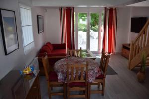 een woonkamer met een tafel en een rode bank bij Dokaetchea in Urrugne