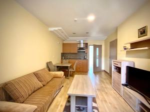 a living room with a couch and a kitchen at Karkle Seaside Apartments in Karklė
