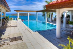 a swimming pool with a view of the ocean at TAMAR VILLA in Virgin Gorda