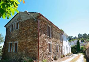 an old brick building on the side of a street at Casa Elena Turismo Rural in Reinante