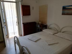 a bedroom with a white bed with two towels on it at La Stanza Alternativa in Sannicola