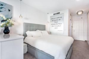 sypialnia z białym łóżkiem i wazą kwiatów w obiekcie by RIVA - Cozy, Contemporary Studio in Puerto Banus Gardens w Marbelli +7 zdjęć
