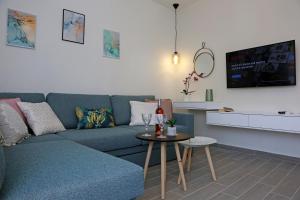 a living room with a blue couch and a table at Under the Aqueduct boutique house in Kavála