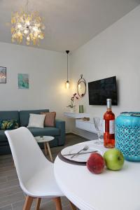 a living room with a white table with a bottle of wine at Under the Aqueduct boutique house in Kavála