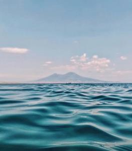 una gran masa de agua con una montaña en el fondo en Holiday House D' Anna 68 en Agerola