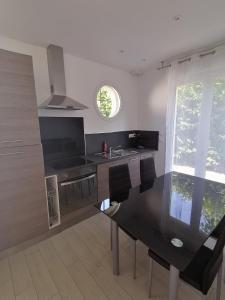 a kitchen with a black counter top and a window at La gravière in Saint-Geours-de-Maremne