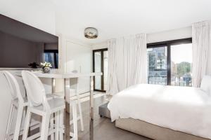 a white bedroom with a bed and a table and chairs at by RIVA - Chic, Contemporary Studio in Puerto Banus Gardens in Marbella