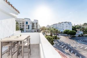 einen Balkon mit einem Tisch und Stühlen auf einem Gebäude in der Unterkunft by RIVA - Chic, Contemporary Studio in Puerto Banus Gardens in Marbella