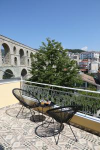 a balcony with two chairs and a table on a roof at Under the Aqueduct boutique house in Kavala