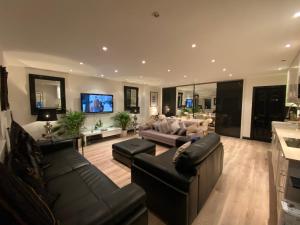 a large living room with couches and a tv at Cockfosters executive Mews in Barnet