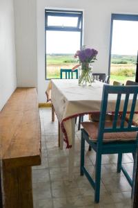 a dining room table with a vase of flowers on it at Harvest Moon-ROOMS ONLY in Doolin