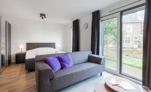 ein Wohnzimmer mit einem Sofa und einem Bett in der Unterkunft Greenstay in Amsterdam