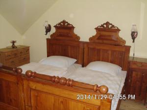 a bedroom with two large wooden beds with white pillows at Petrovický mlýn in Kasanice