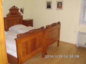 a bedroom with a wooden bed with white sheets at Petrovický mlýn in Kasanice