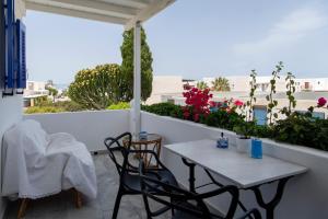 patio con mesa y sillas en el balcón en Ricos Two Bedroom House - Naoussa Paros, en Naousa