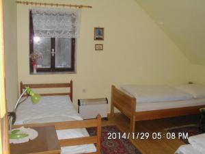 a bedroom with two beds and a window at Petrovický mlýn in Kasanice