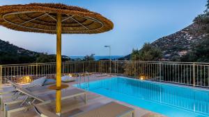 eine Terrasse mit einem Sonnenschirm und einem Pool in der Unterkunft Summer Villas Crete in Balíon