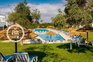 - une piscine avec des chaises longues et des parasols dans l'établissement Pateo Village, à Albufeira