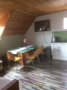 a dining room with a table and chairs and a kitchen at Apartman Luca in Nyíregyháza